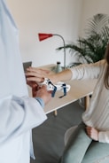 person in white long sleeve shirt holding white textile