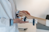 person in white coat holding silver and blue ring