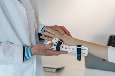 person in white coat holding silver and blue ring patient google meet background