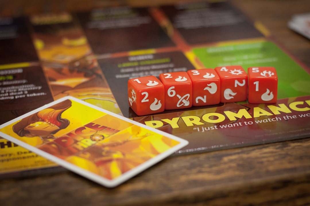 red and yellow labeled box, Pyromancer die from Dice Throne Season 1.