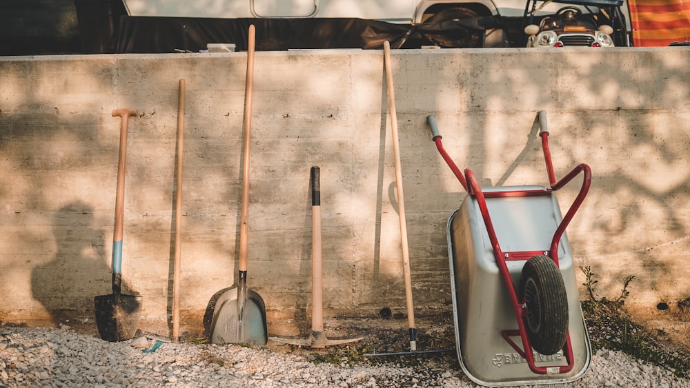 red and black shovel beside brown wooden stick