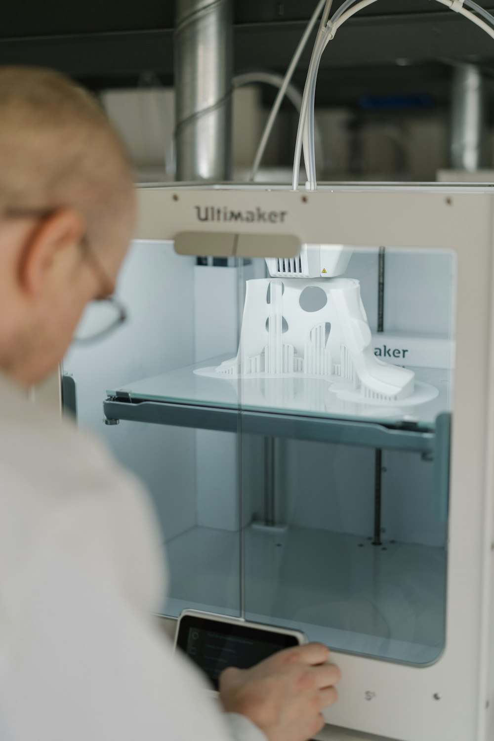 person in white shirt using sewing machine