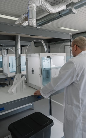 man in white laboratory gown standing near white and black machine