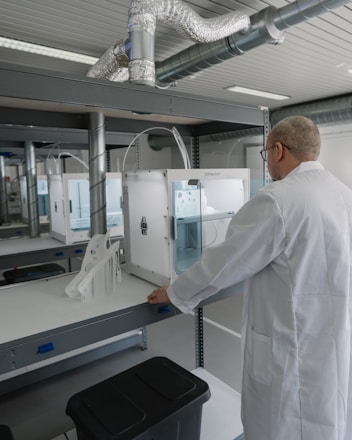 man in white laboratory gown standing near white and black machine