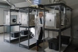 man in white button up shirt standing beside white machine
