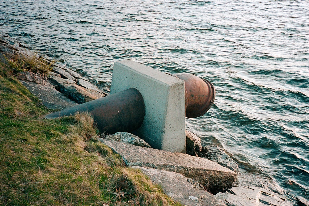 gray concrete post near body of water during daytime
