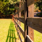 brown wooden fence on green grass field during daytime