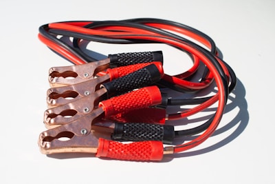 An AfriJump jumper cable set glowing softly under blue electric lighting.