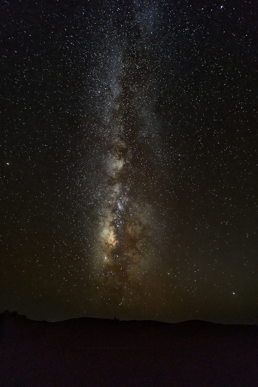 silhouette of mountain under starry night