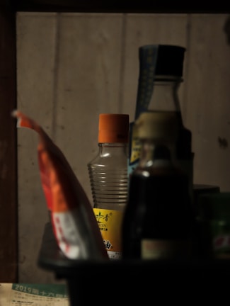 Close-up of black cabinets filled with a variety of colorful products under soft lilac lighting.