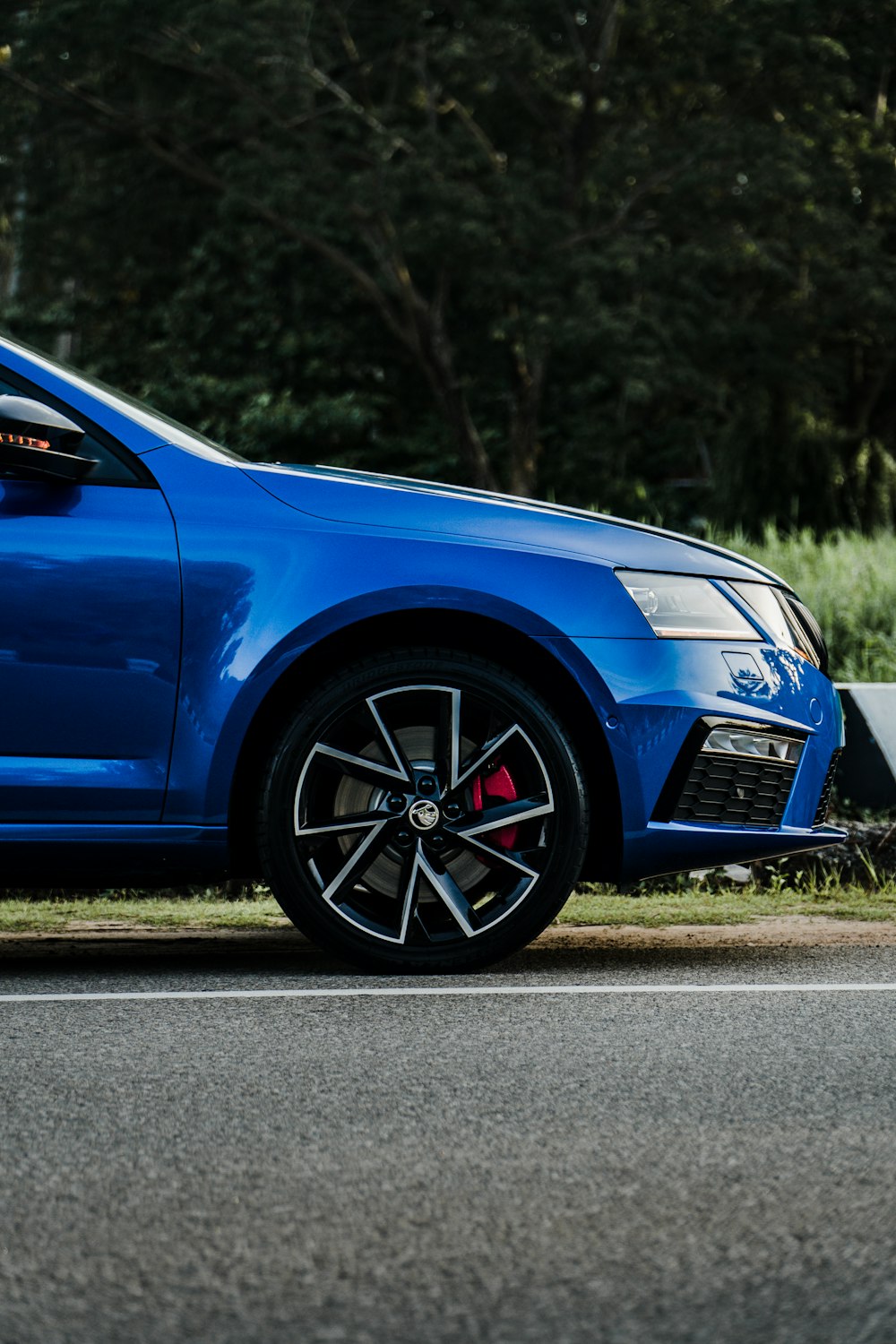 blue car on gray asphalt road during daytime