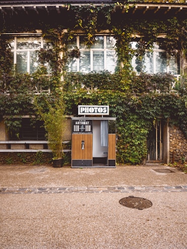 brown wooden door near green trees during daytime
