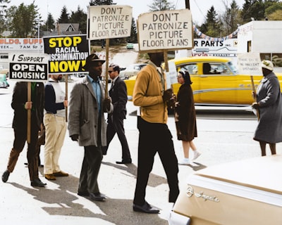 protestors hold signs reading 