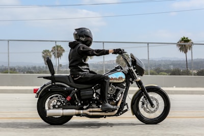 man in black leather jacket riding black motorcycle during daytime
