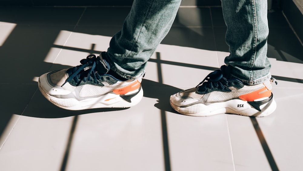 person in blue denim jeans wearing black and white nike sneakers