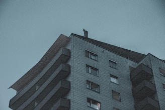 Photo of a condominium building with a manager discussing with residents.