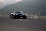 A vibrant Ferrari during a test drive on a scenic road.