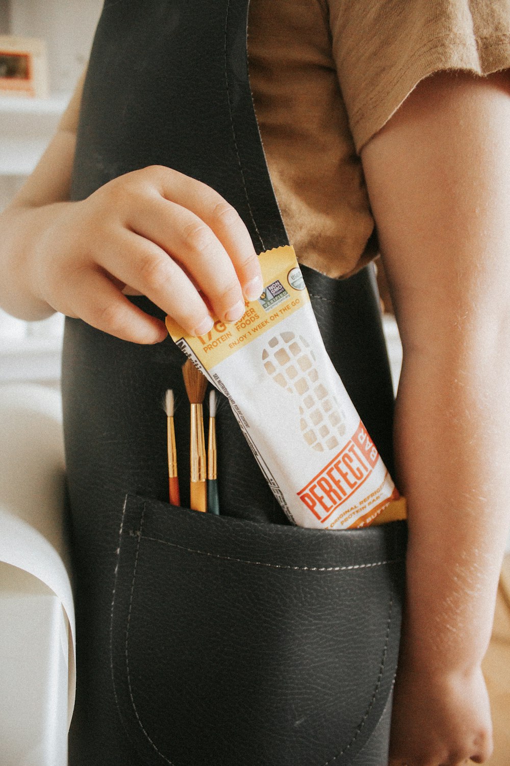 person holding white and orange plastic pack