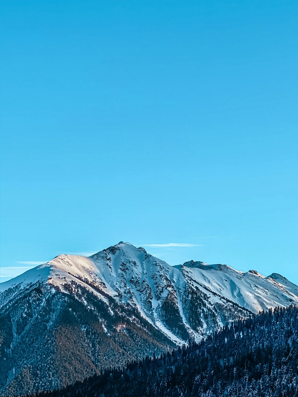 snow covered mountain under blue sky during daytime