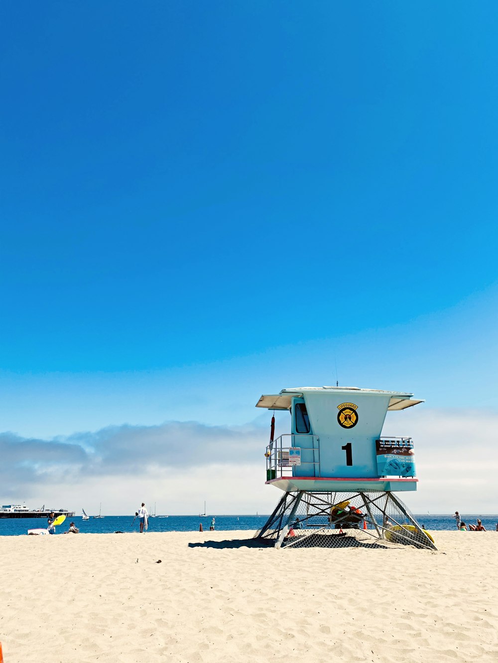 white lifeguard house on beach during daytime