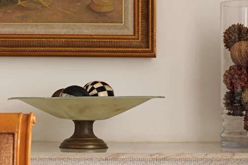 Elegant umbrella stand next to a decorative bowl filled with seasonal accents