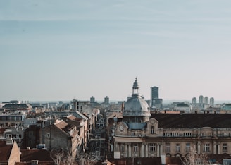A panoramic view of a historic city skyline under a clear blue sky.
