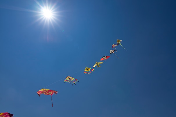 Children releasing colorful kites into a bright blue sky, symbolizing new beginnings.