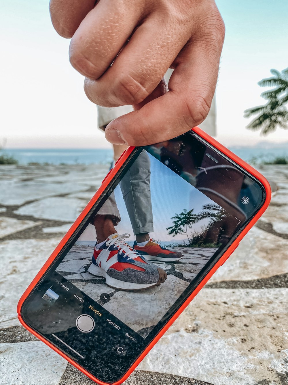 person holding iphone 6 with orange case