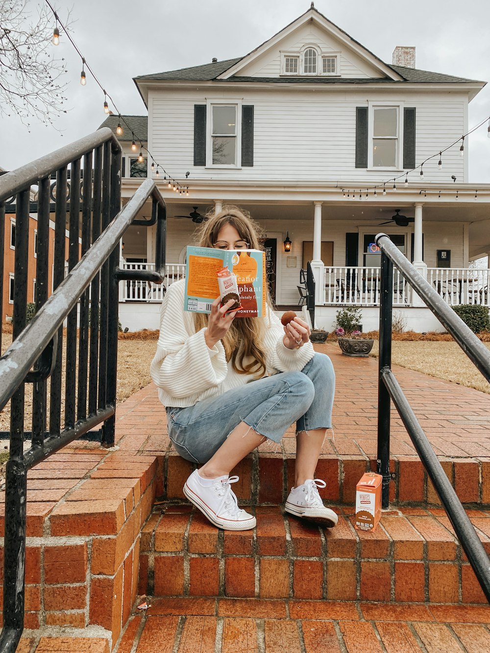 woman in gray shirt sitting on brown concrete stairs