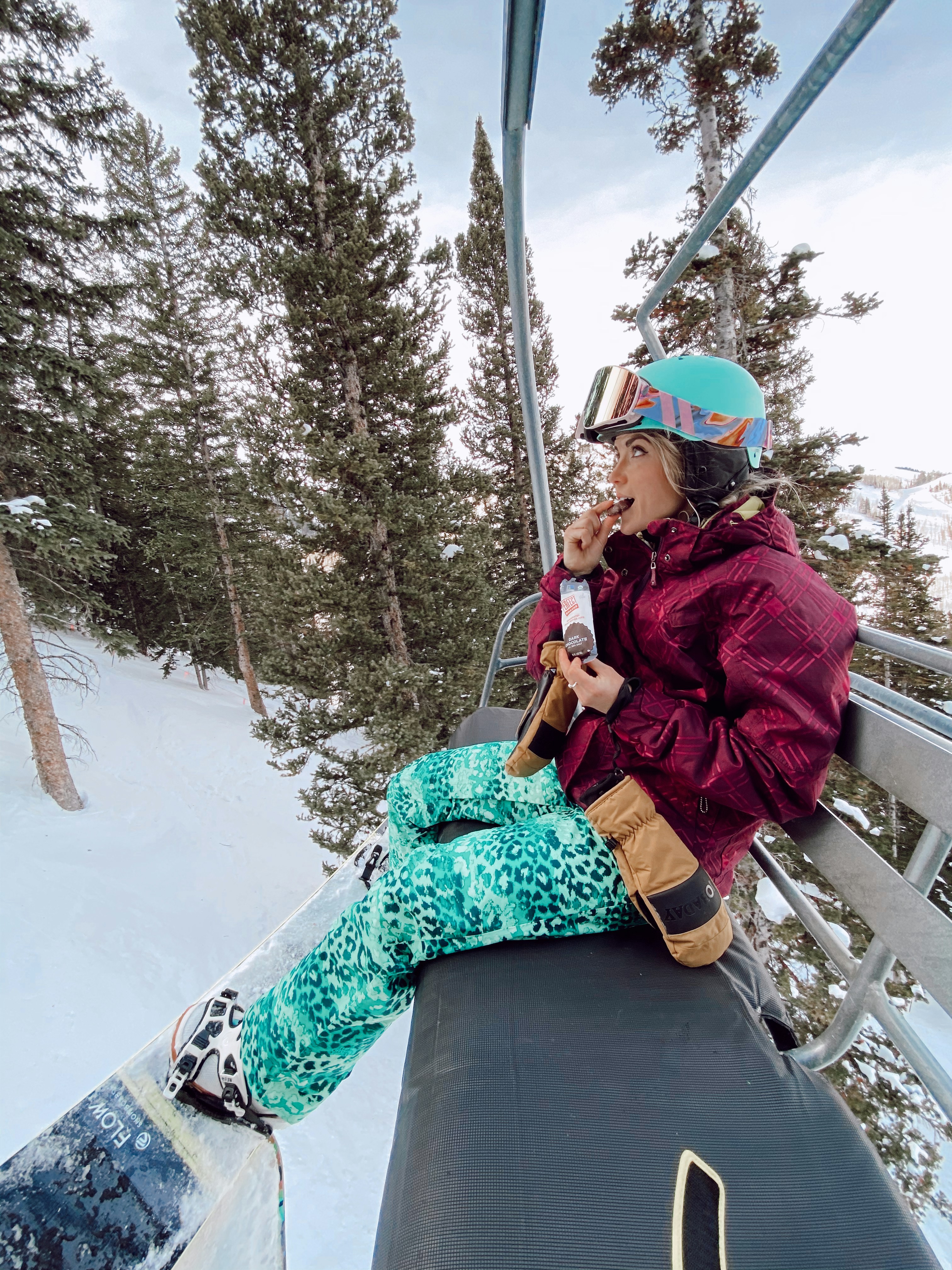 Frau in rosa Jacke sitzt tagsüber auf brauner Holzbank