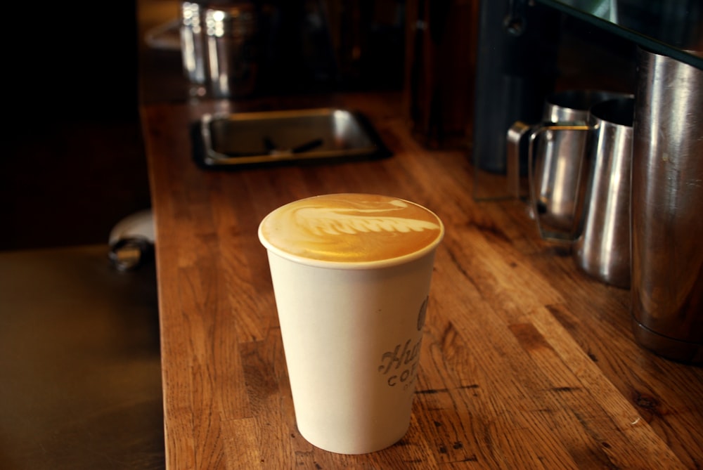 white disposable cup on brown wooden table