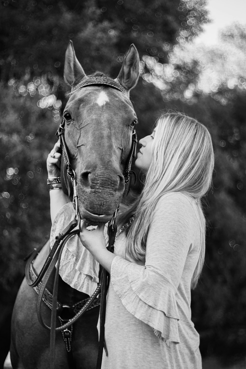woman in long sleeve shirt kissing horse