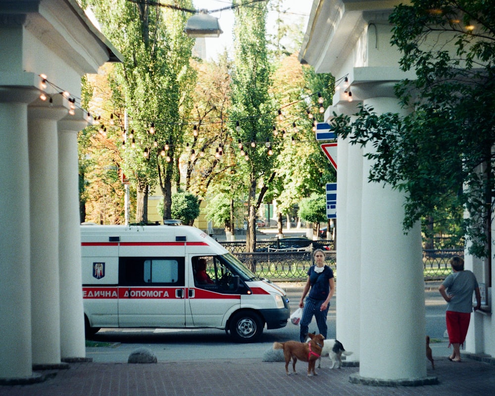 man in blue t-shirt standing beside white and red van during daytime