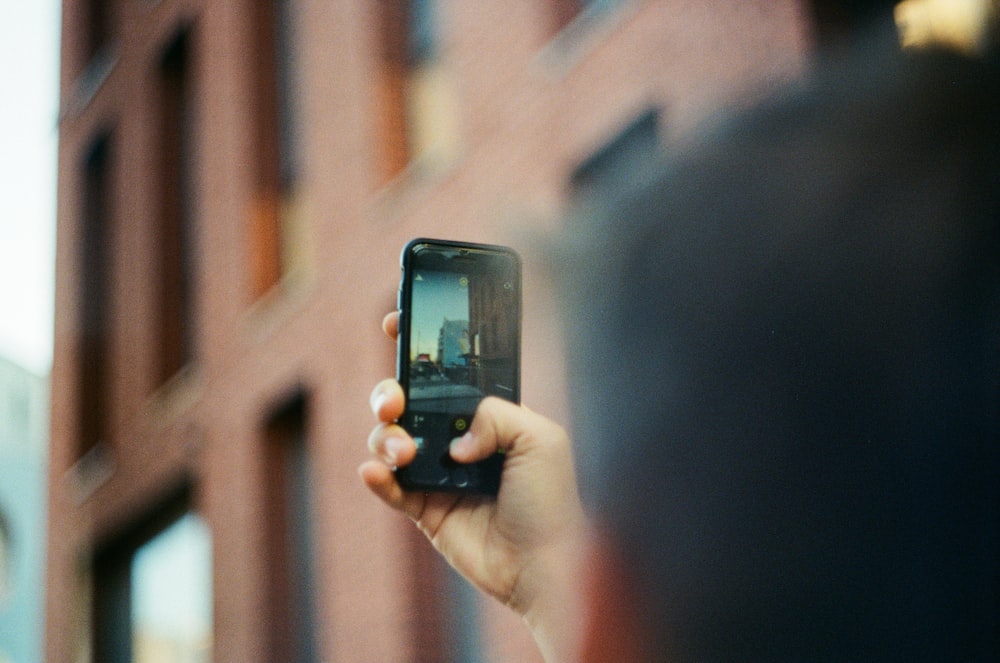 person holding black iphone 5