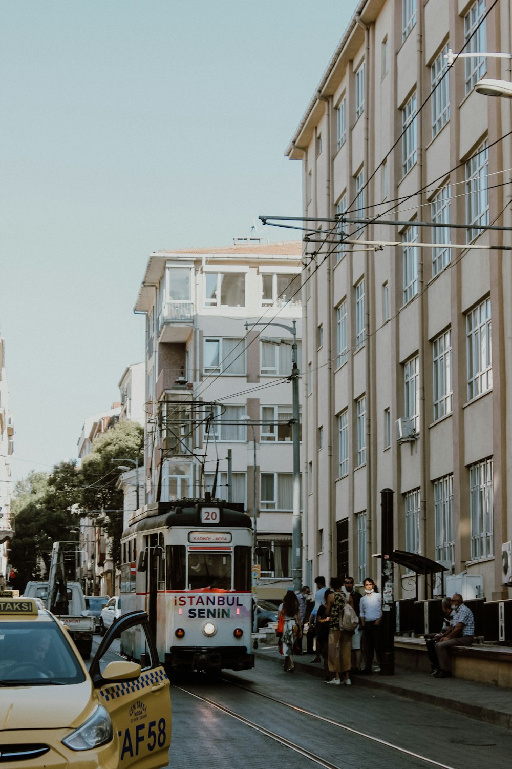 les personnes qui marchent dans la rue près des bâtiments pendant la journée ;