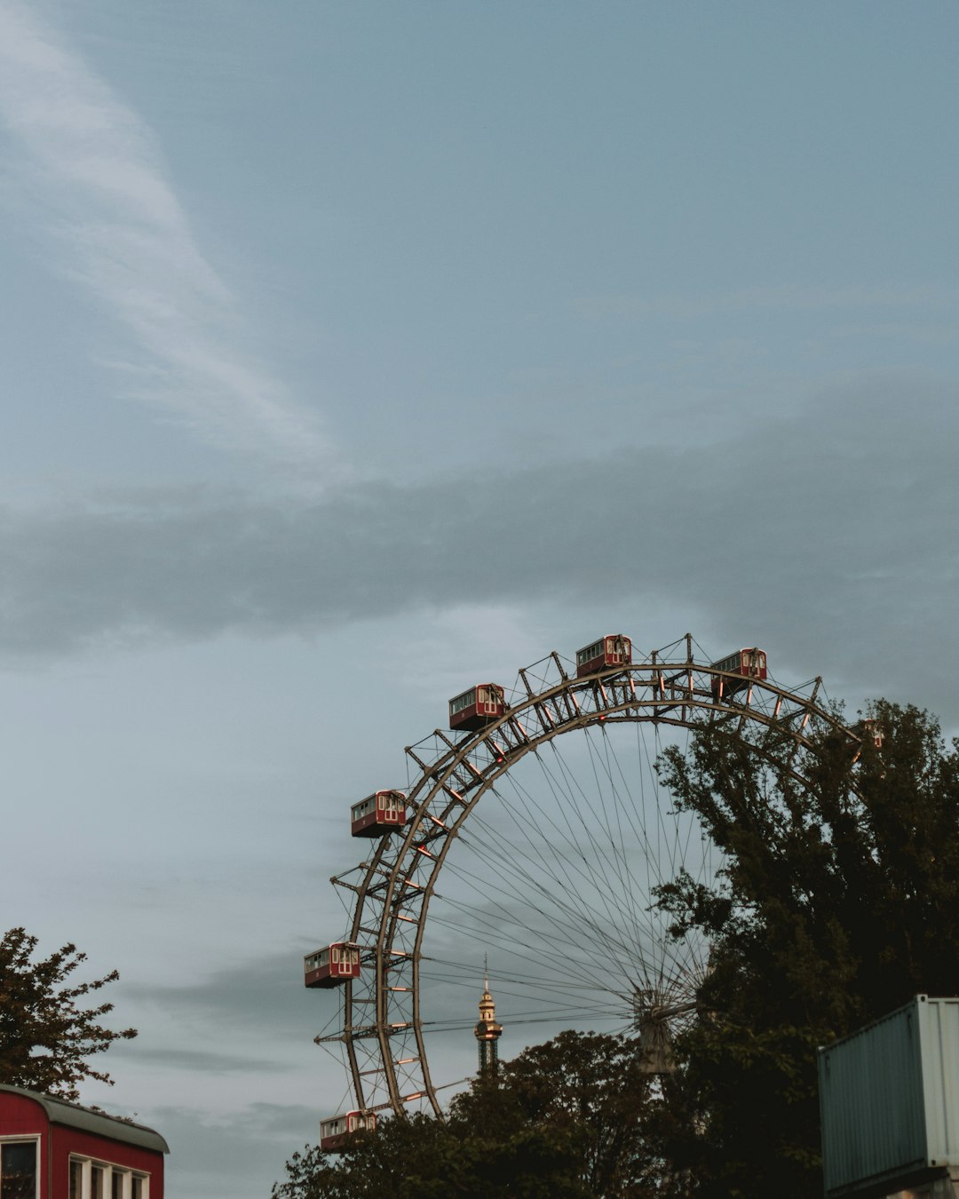 ferris wheel near green trees under gray sky