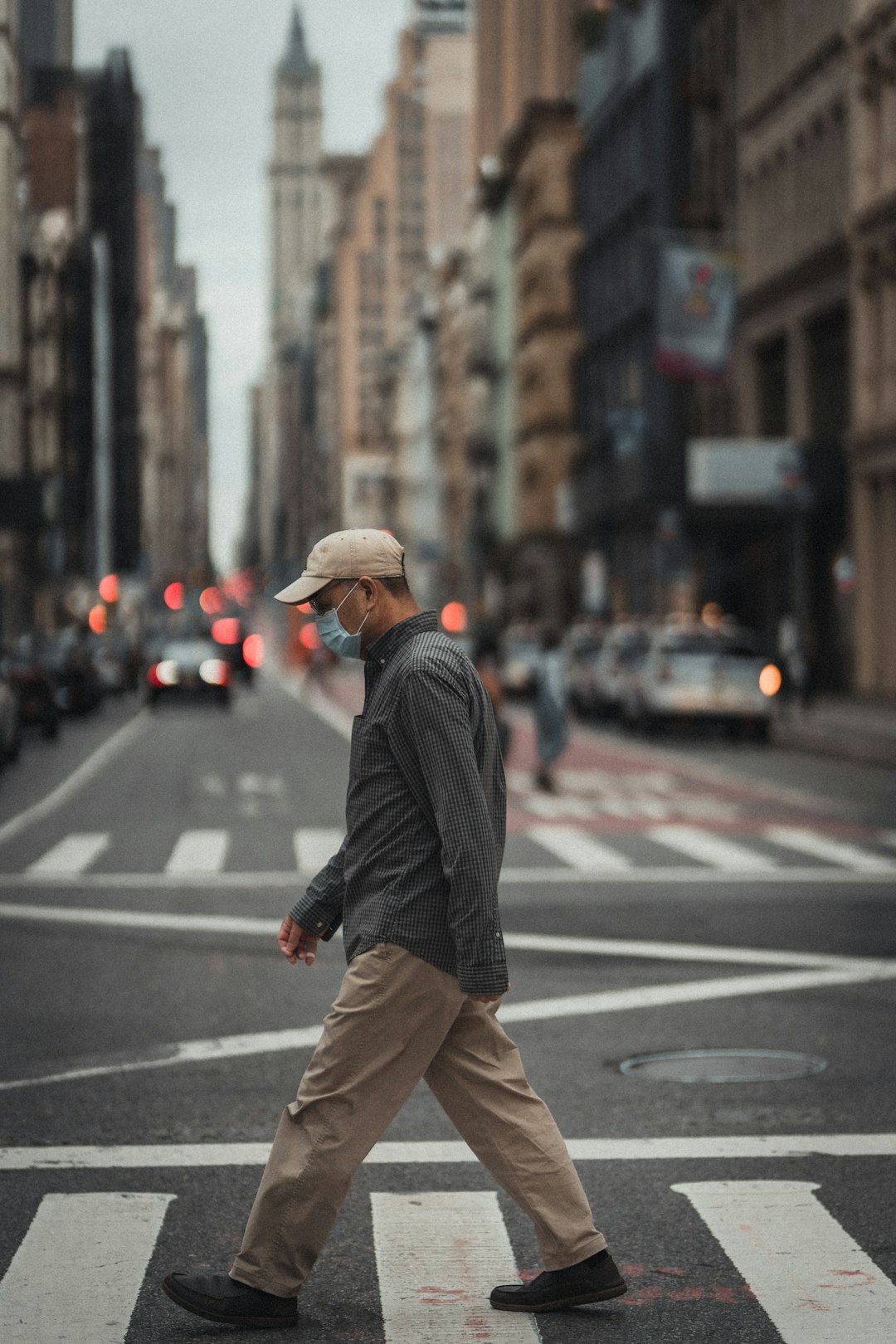man in black and white pinstripe dress shirt and brown pants walking on pedestrian lane during