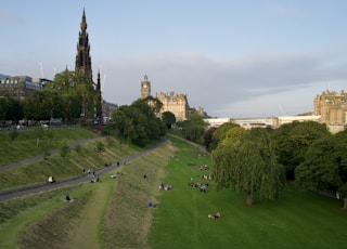 people on green grass field near brown concrete building during daytime