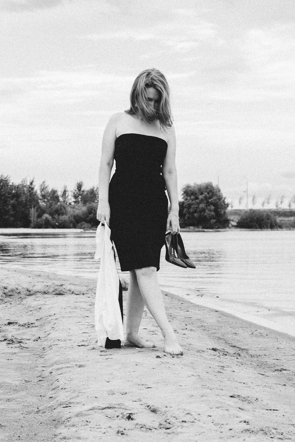 woman in black tank top and white pants standing on beach