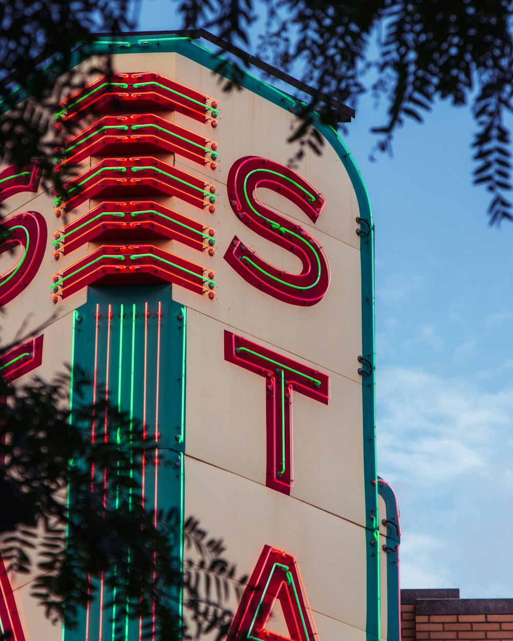 a tall building with a neon sign on it's side