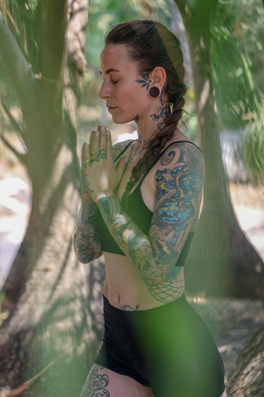 woman in green and black long sleeve shirt holding white flower