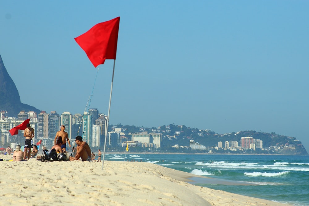 a group of people sitting on top of a sandy beach