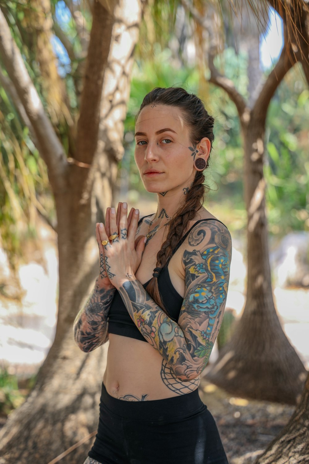 woman in black and blue floral brassiere and panty standing near tree during daytime