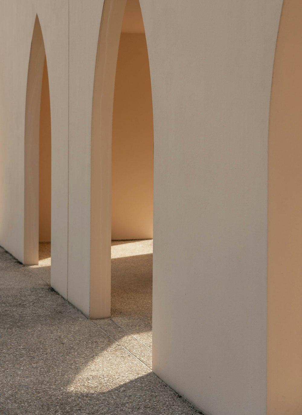 a white building with arches and a clock on the wall