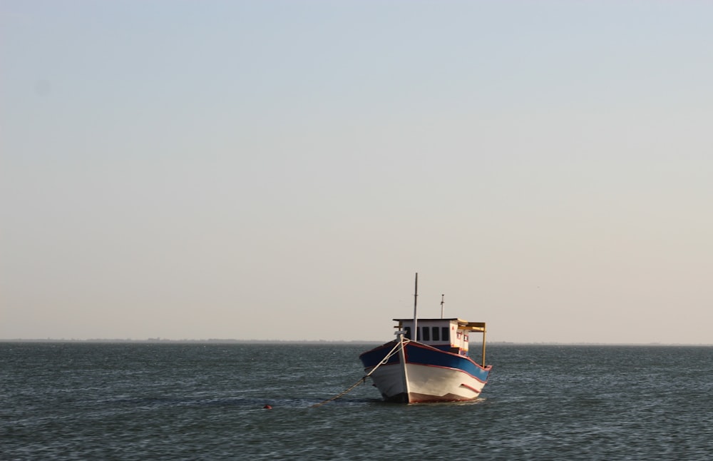 昼間の海上に浮かぶ白と茶色のボート