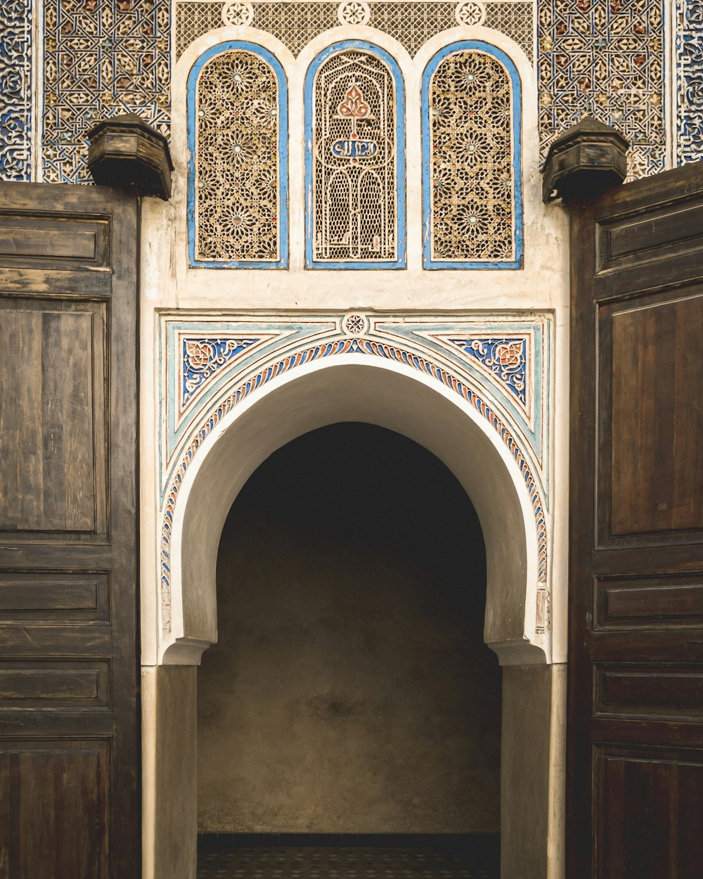 porta de madeira marrom com parede floral azul e branca