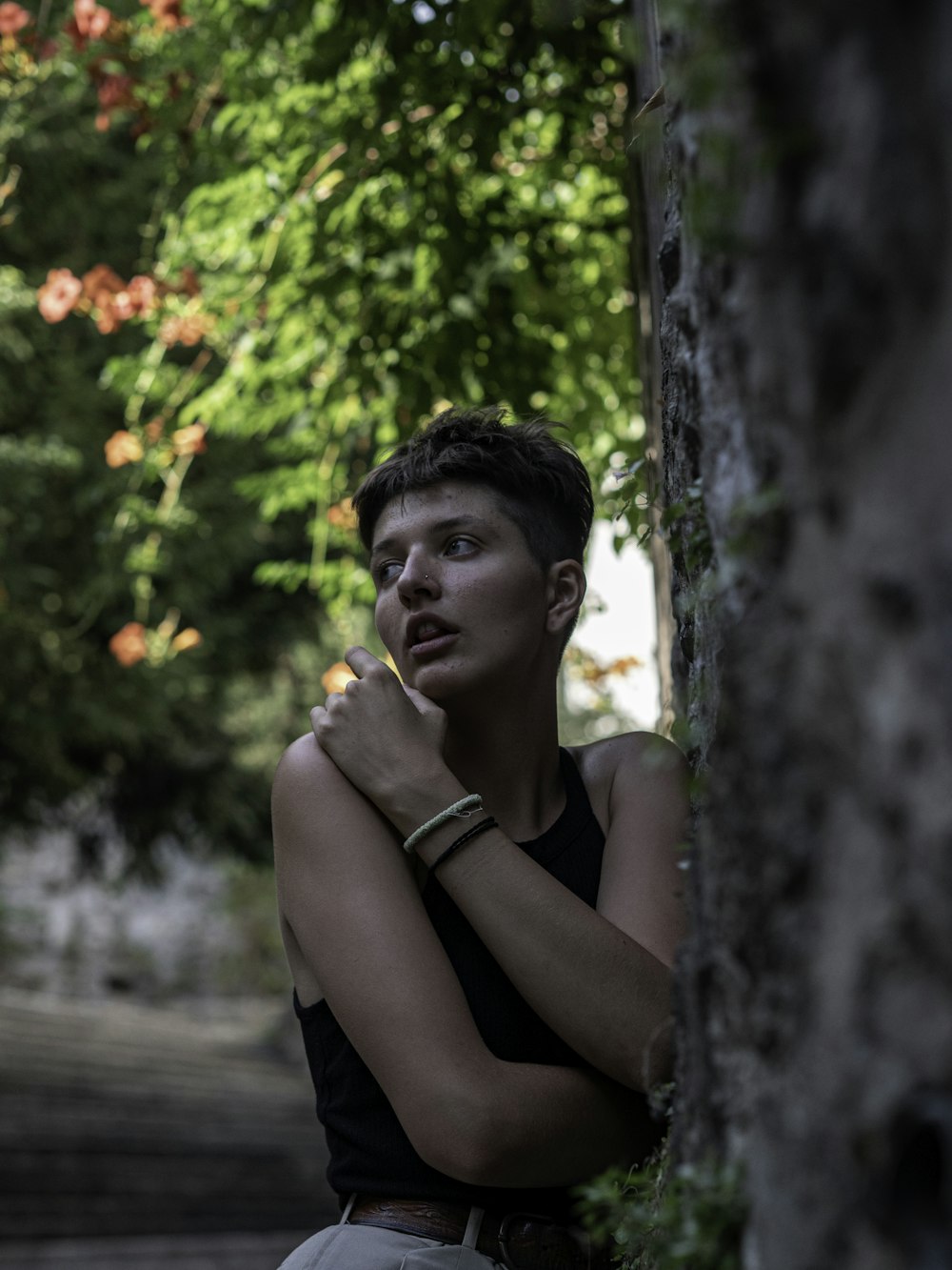 woman in black tank top sitting on brown wooden bench