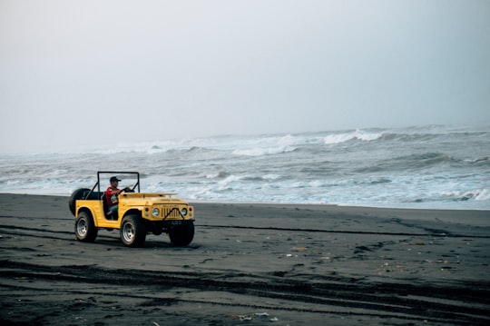 yellow jeep wrangler on beach during daytime in Parangtritis Beach Indonesia