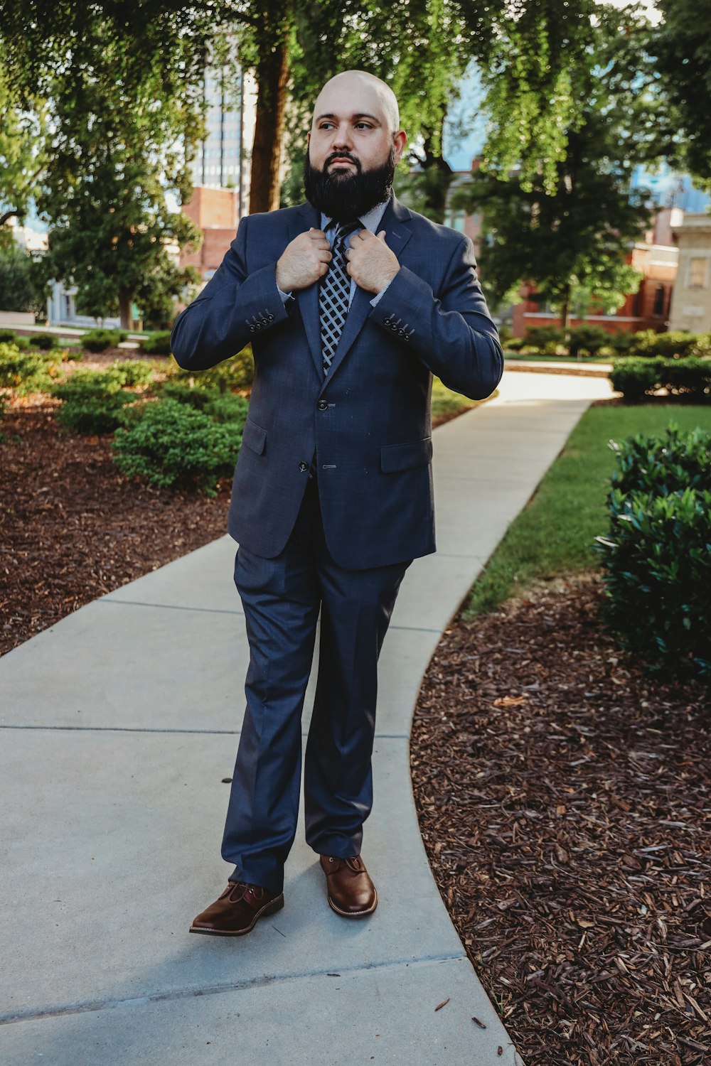 man in black suit jacket and gray pants standing on gray concrete floor