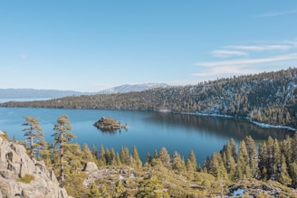 blue lake surrounded by green trees under blue sky during daytime
